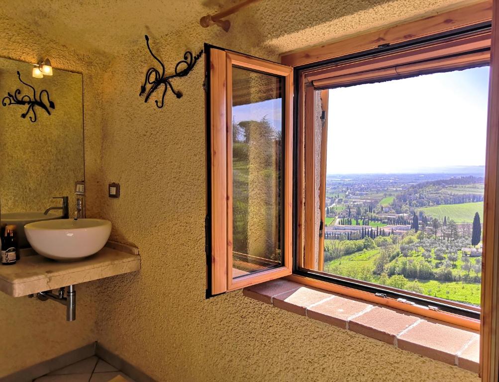a bathroom with a sink and a window with a view at Nero Gioconda in Anghiari
