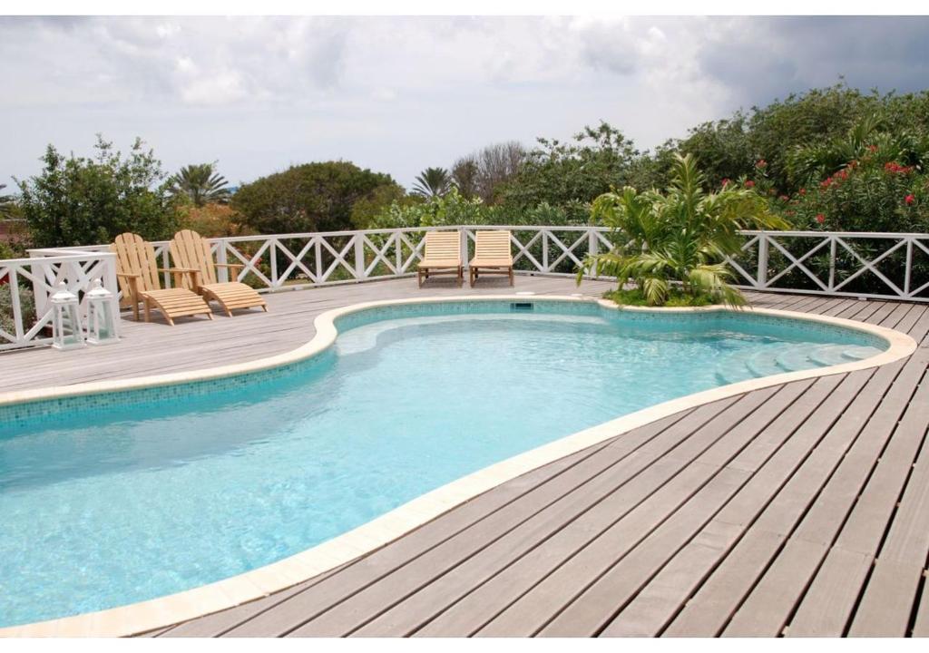 - une piscine sur une terrasse en bois avec des chaises et une terrasse dans l'établissement Casa Troepiaal, à Willemstad