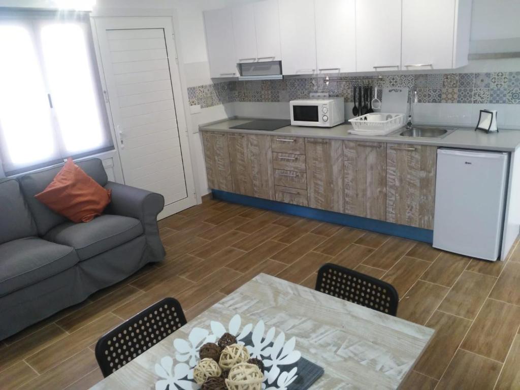 cocina y sala de estar con mesa y sofá. en SALEMA en Caleta de Sebo