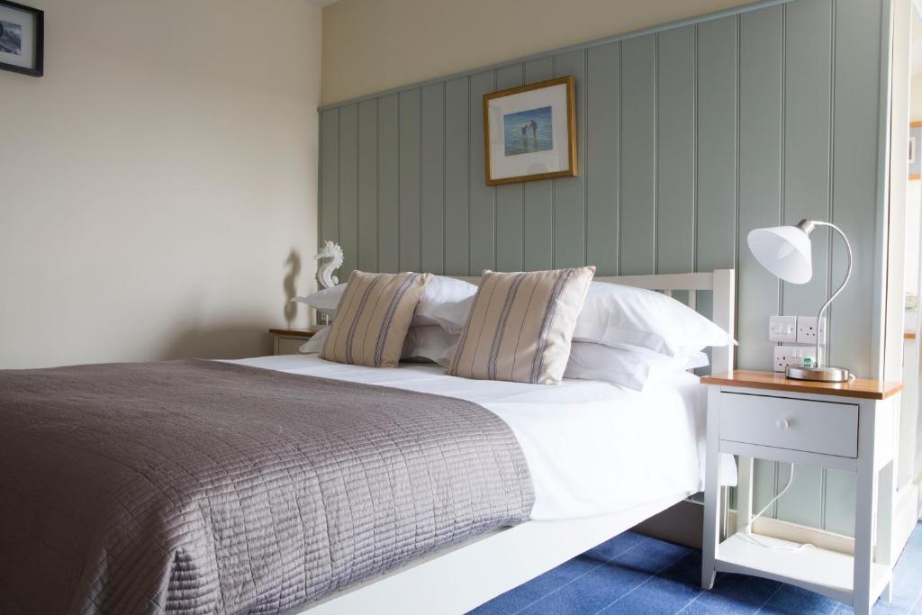 a bedroom with a large bed and a table with a lamp at Seacroft in Holyhead