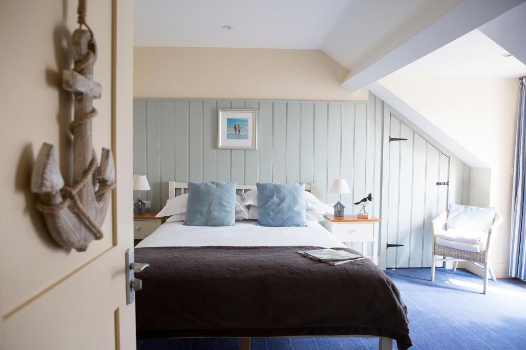 a bedroom with a large bed with blue pillows at Seacroft in Holyhead