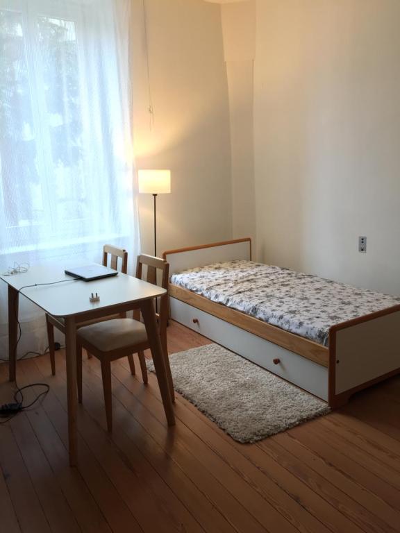 una camera da letto con un letto, un tavolo e una scrivania di les camélias a Mazamet
