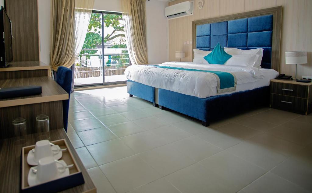 a bedroom with a large bed with a blue headboard at Riviera Suites in Lagos