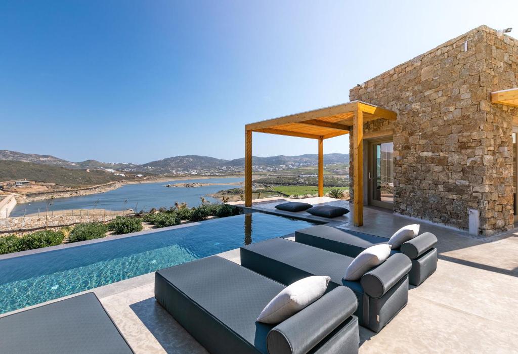a villa with a swimming pool and a house at Panormos Bay Suites in Mykonos