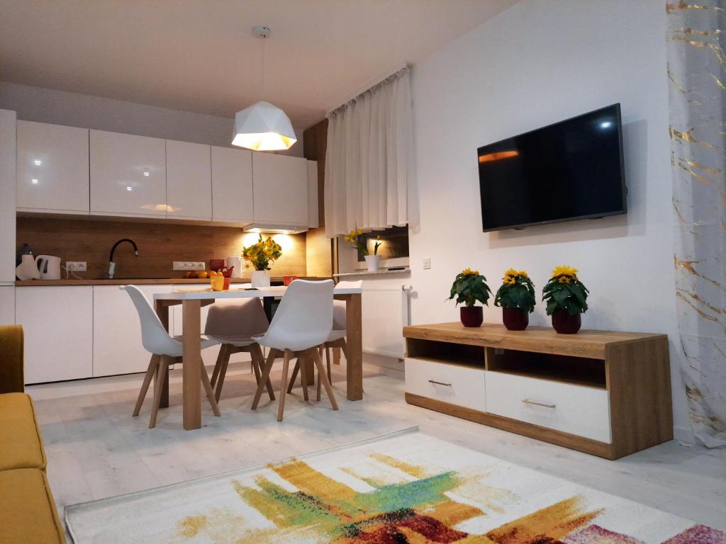een keuken en woonkamer met een tafel en stoelen bij Apartament Amber Comfort z prywatnym miejscem parkingowym in Kołobrzeg