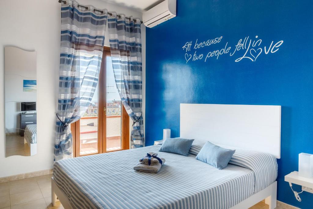 a bedroom with a bed with a blue wall at Sunset Roof in Anzio