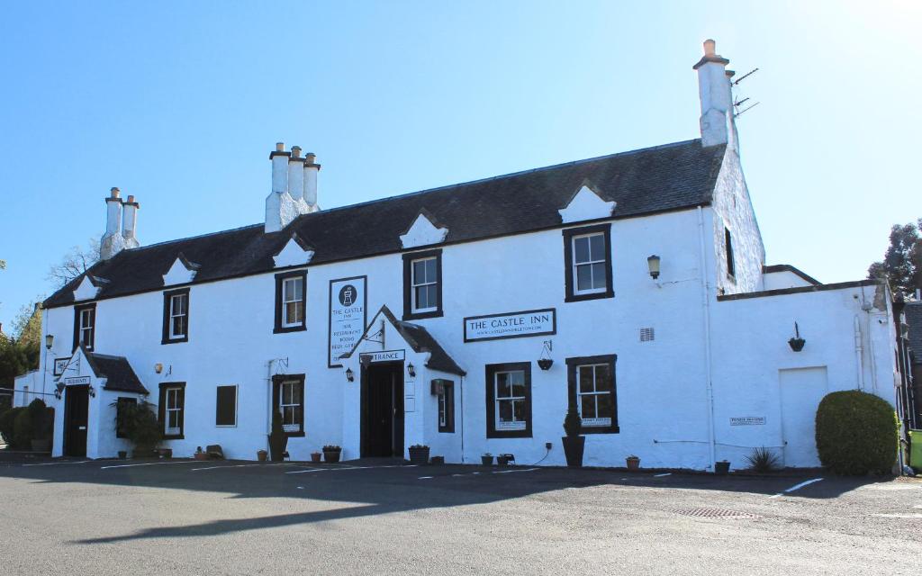 un gran edificio blanco con un cartel. en The Castle Inn en Dirleton