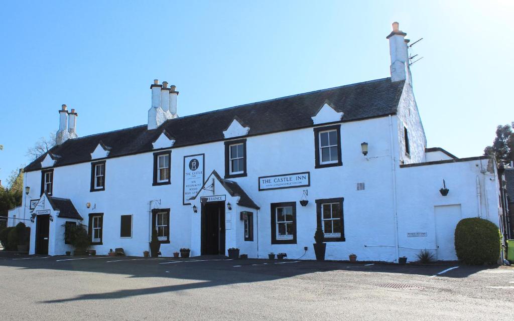 a large white building with a sign on it at The Castle Inn in Dirleton