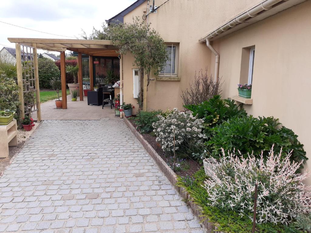 uma passagem em frente a uma casa com plantas em petit coin au calme em Baulon