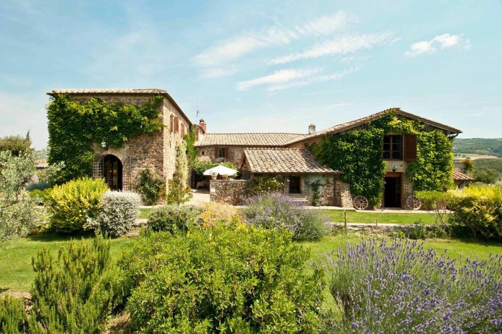 a stone house with a garden in front of it at Villa Lorian in Argiano