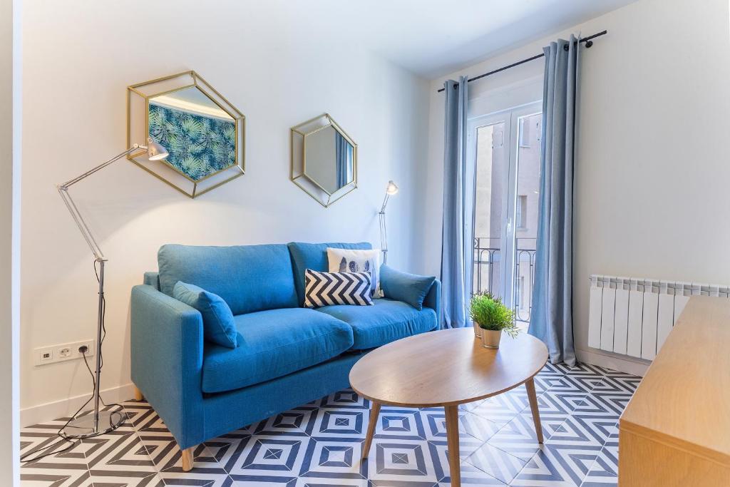 sala de estar con sofá azul y mesa en MIT House Rio Plaza en Madrid, en Madrid