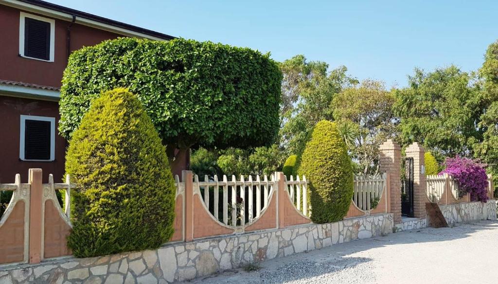 una recinzione di fronte a una casa con cespugli di Capo Rizzuto Home a Capo Rizzuto