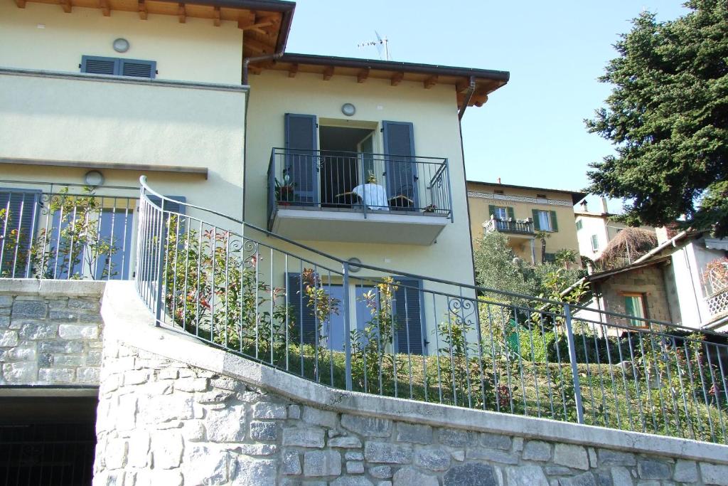 a building with a balcony with a man sitting on a window at Casavalery Appartamento monolocale con vista lago in Bellagio