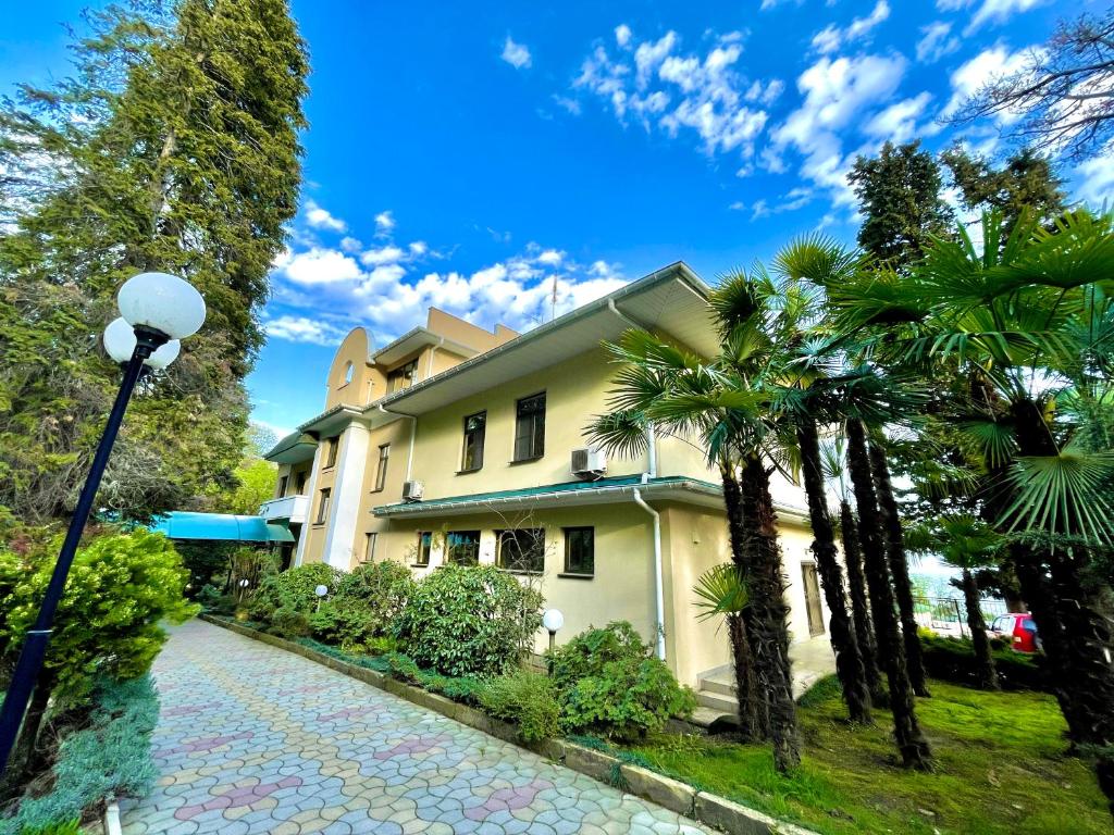 a house with palm trees and a street light at Rest-Matsesta Hotel in Sochi