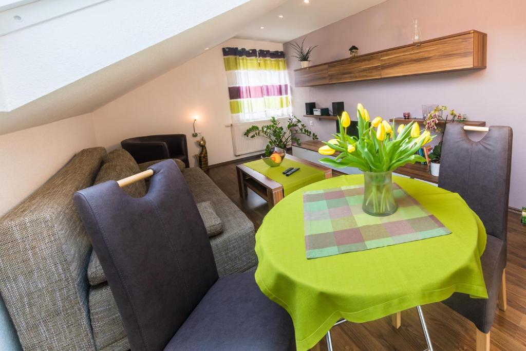 a living room with a couch and a table with flowers at Ferienwohnung Groß Taubertal in Königheim