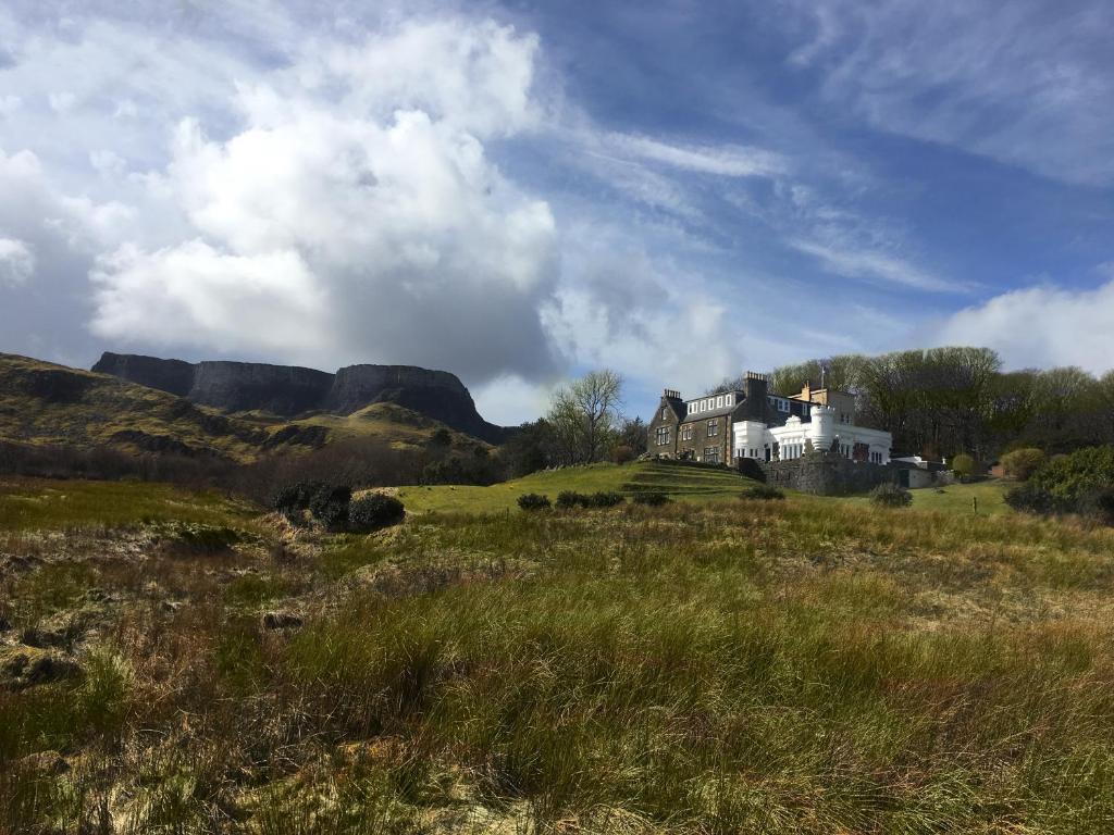 a house on top of a hill in a field at Flodigarry Hotel and SKYE Restaurant in Staffin