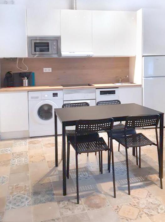 a kitchen with a table and chairs in a kitchen at Campo del Sur - Catedral in Cádiz