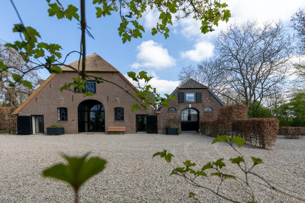 un grande edificio in mattoni con una panca di fronte di Het Rentmeestershuis a Eck en Wiel