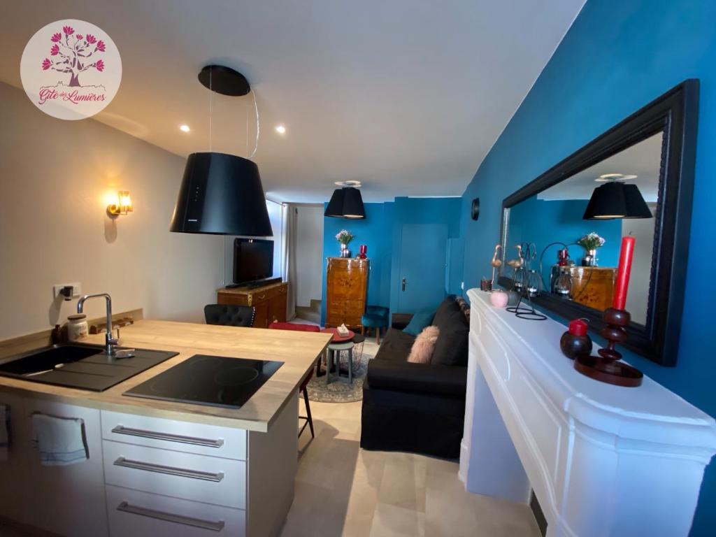 a kitchen with a sink and a living room at Le Gîte des Lumières in Langres