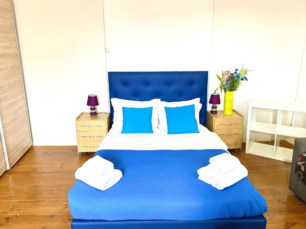 ein blaues Bett mit blauen Kissen im Schlafzimmer in der Unterkunft Chiado Central Guest House Lisbon Room Classic with shared bathroom in Lissabon