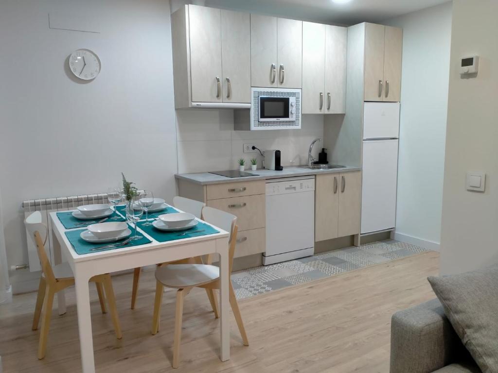 a kitchen with a table and chairs in a room at Apartamentos Adarve in Ciudad-Rodrigo