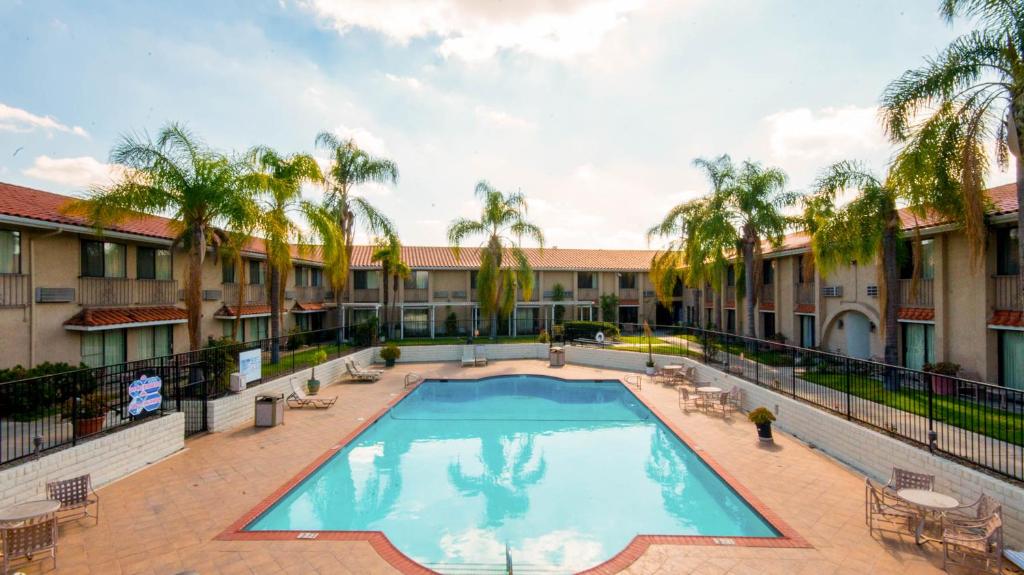 a large pool in a courtyard with palm trees at Studio 6 Anaheim Hills CA in Anaheim