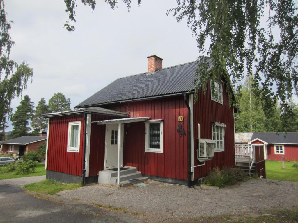 a red house with a white door and a porch at TORPET (Villa Solsidan), Hälsingland, Sweden in Arbrå