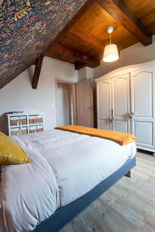 a large bed in a room with wooden ceilings at Gîtes Au fil des saisons proximité EUROPA PARK in Diebolsheim