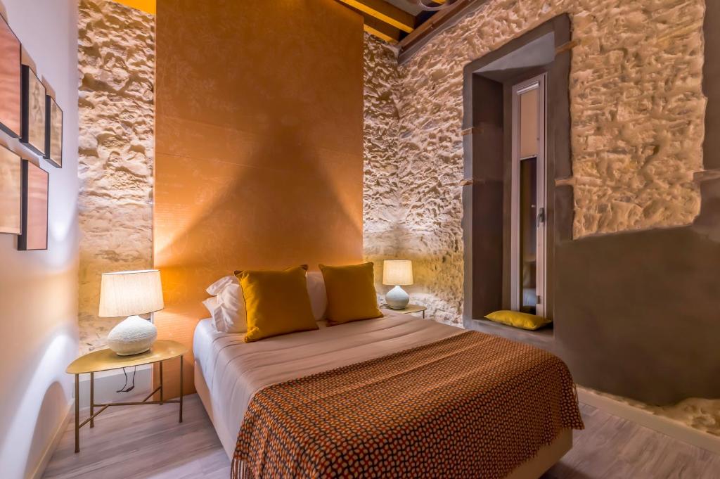 um quarto com uma cama king-size e almofadas amarelas em Bacharéis Charming House em Figueira da Foz
