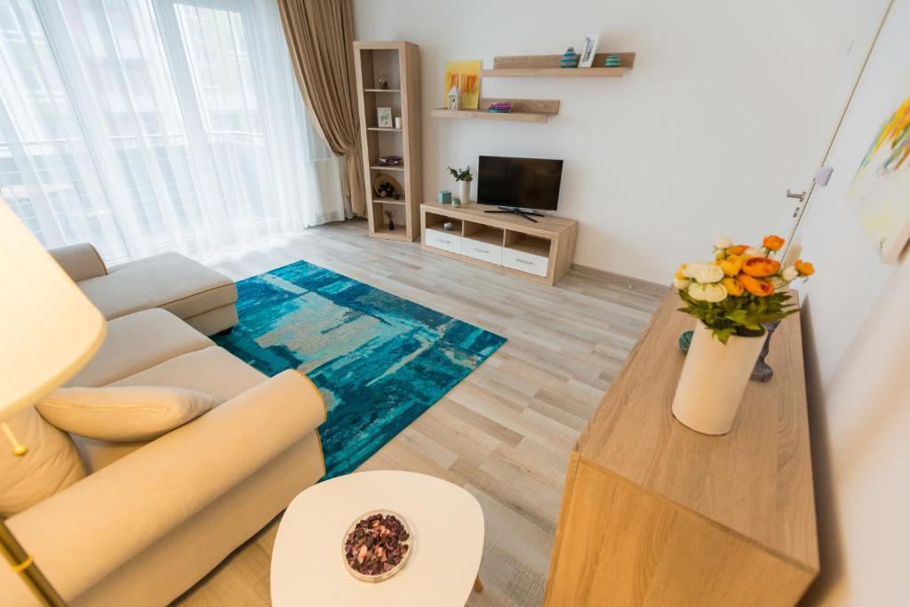 uma sala de estar com um sofá e uma mesa em RentForComfort Apartment Ella em Brasov