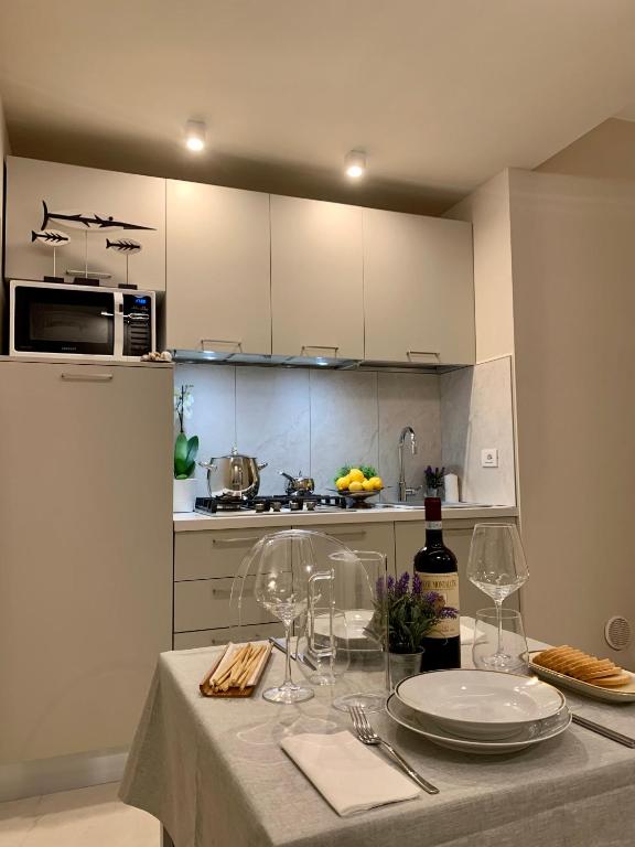 a kitchen with a table with plates and wine glasses at Villa Luminosa in Torre del Lago Puccini