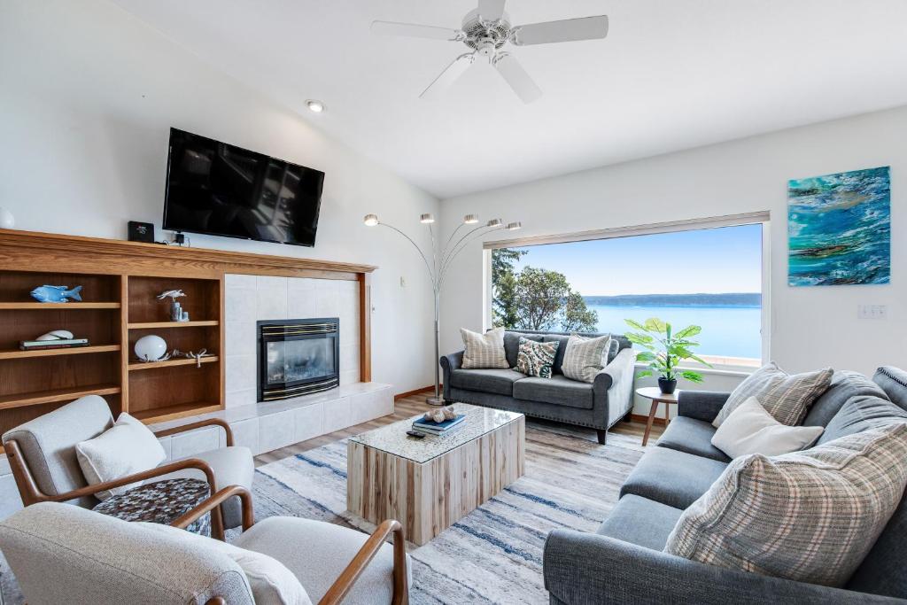 a living room with a fireplace and a tv at Hook & Cook Beach House in Brinnon