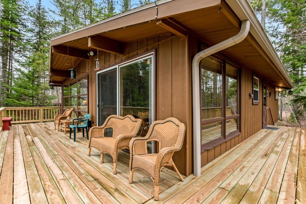 a deck with wicker chairs on a house at Lakeview North in Lac du Flambeau