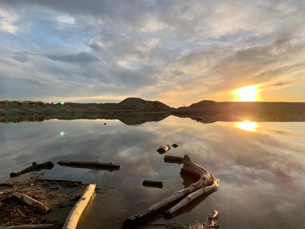 a body of water with the sun setting in the background at Villa Luminosa in Torre del Lago Puccini
