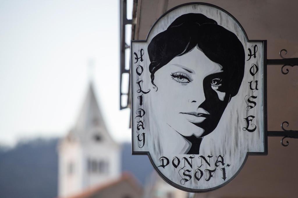 um sinal de uma mulher ao lado de um edifício em Donna Sofi Holiday House em Agerola