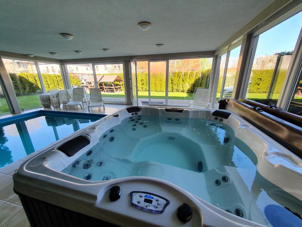 duża wanna w domu z basenem w obiekcie Black Brothers Wellness Apartments w Siófoku