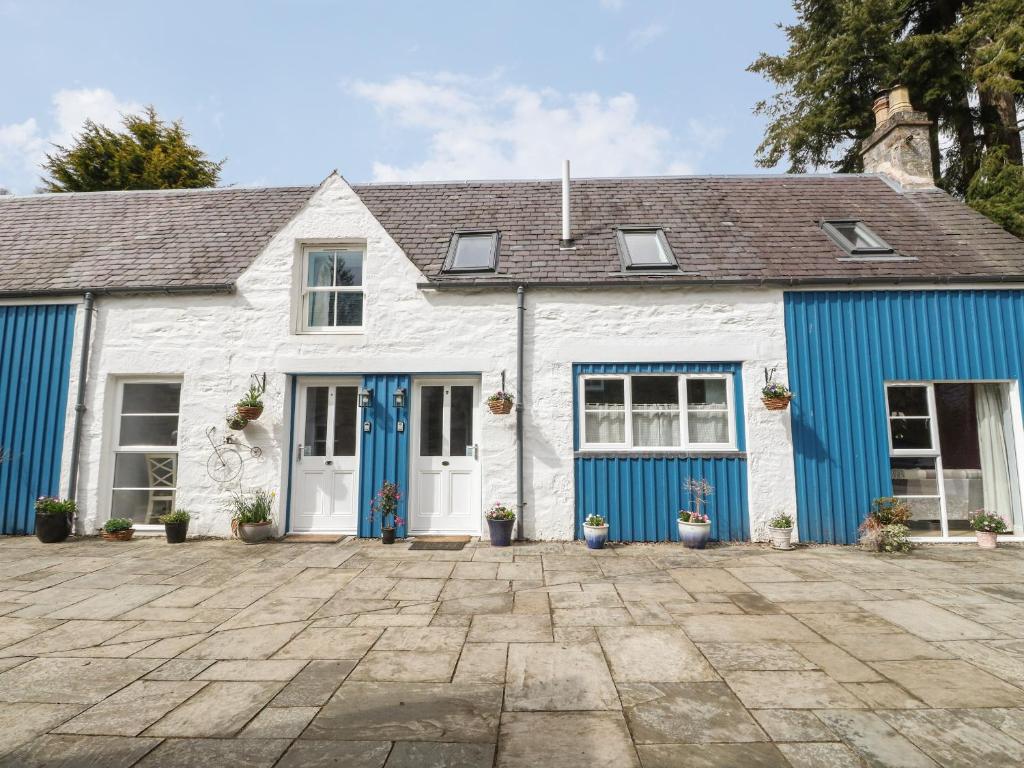 a white and blue house with blue doors at Verdi in Pitlochry