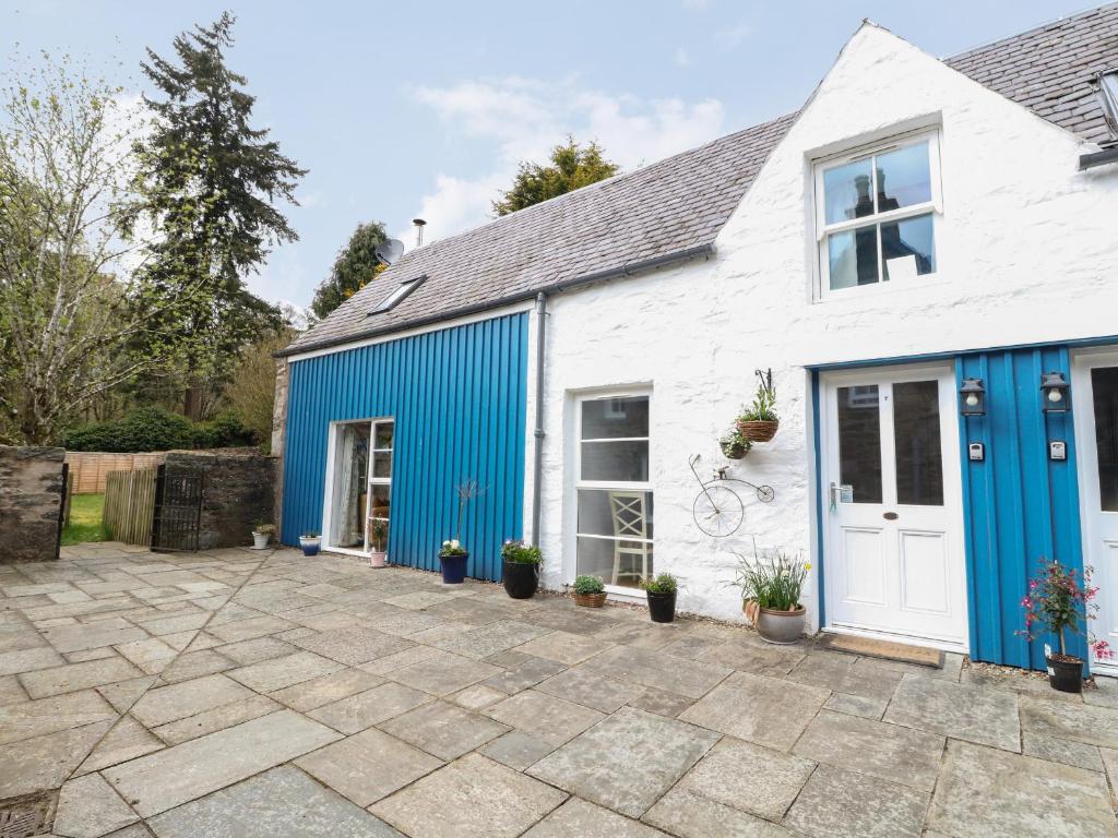 Casa blanca y azul con patio en Puccini en Pitlochry