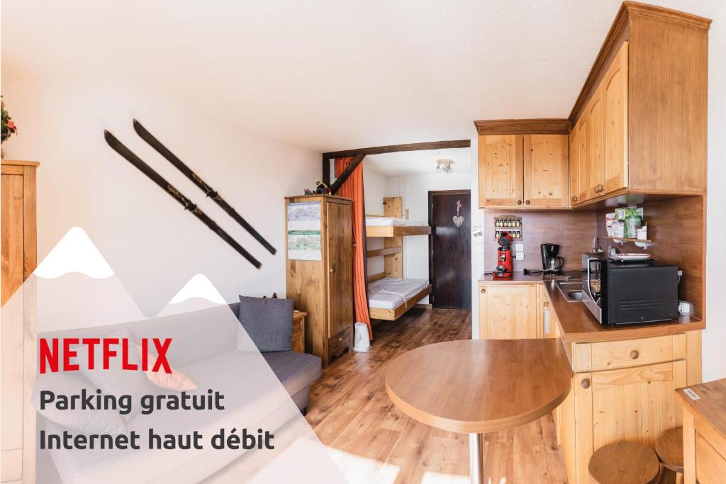 a kitchen with wooden cabinets and a table at L'écrin du Vernon in Chamrousse