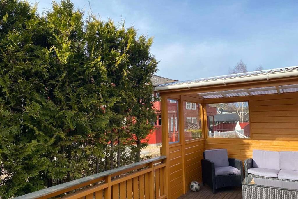a porch with a christmas tree and a chair at Marikollen, spacious appartment with sunny veranda in Kristiansand