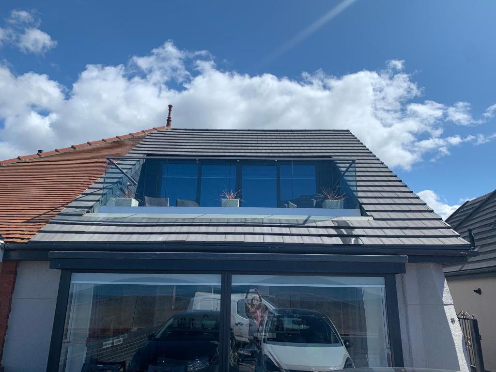 a house with a car parked in front of a window at Beach View Apartment with balcony and sea view - pet friendly in Cleveleys