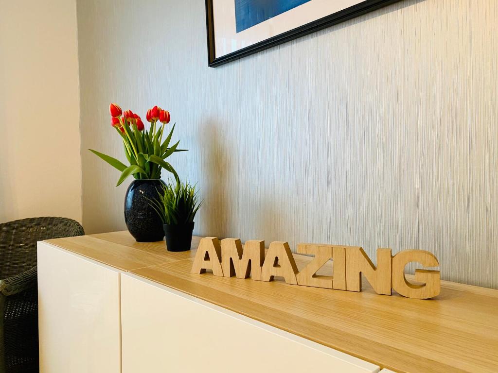 a wooden sign on top of a cabinet with flowers at Enks Home Bed & Breakfast in Bakum