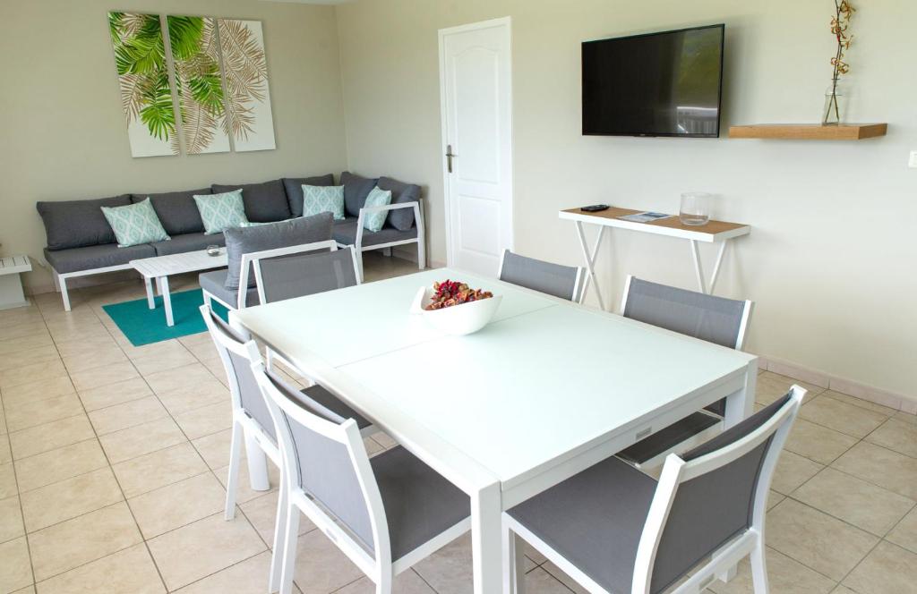 a living room with a white table and chairs at Kaz O'Rocher - Sea View Appartements in Le Diamant