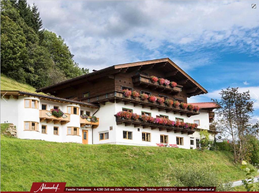 a building on a hill with flower boxes on it at "Adamerhof" in Gerlosberg