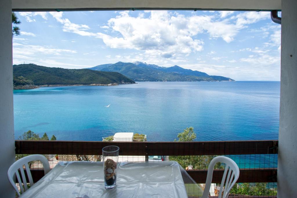 una mesa en un balcón con vistas al agua en Casa Sabrina, en Portoferraio