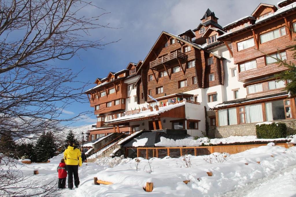 a couple of people standing in the snow in front of a building at Club Hotel Catedral in San Carlos de Bariloche