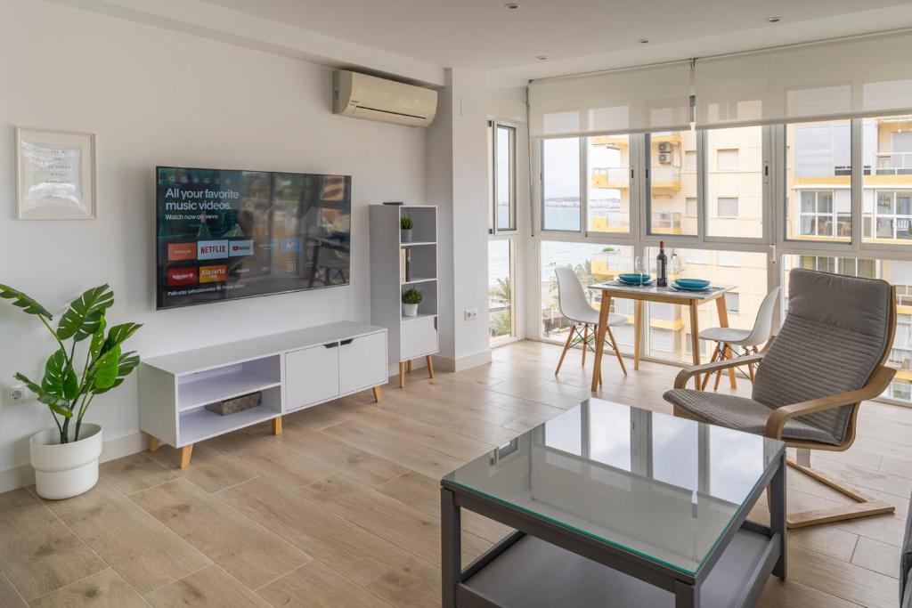 sala de estar con TV y mesa en Apartamento con vistas al mar recién renovado - Montevideo Beach en Algarrobo-Costa