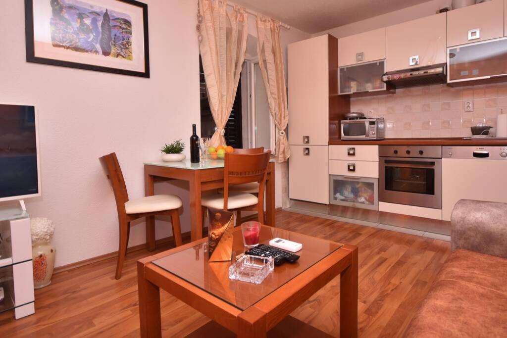 uma sala de estar com uma mesa e uma cozinha em Cozy, adorable apartment ELIZABETA em Split