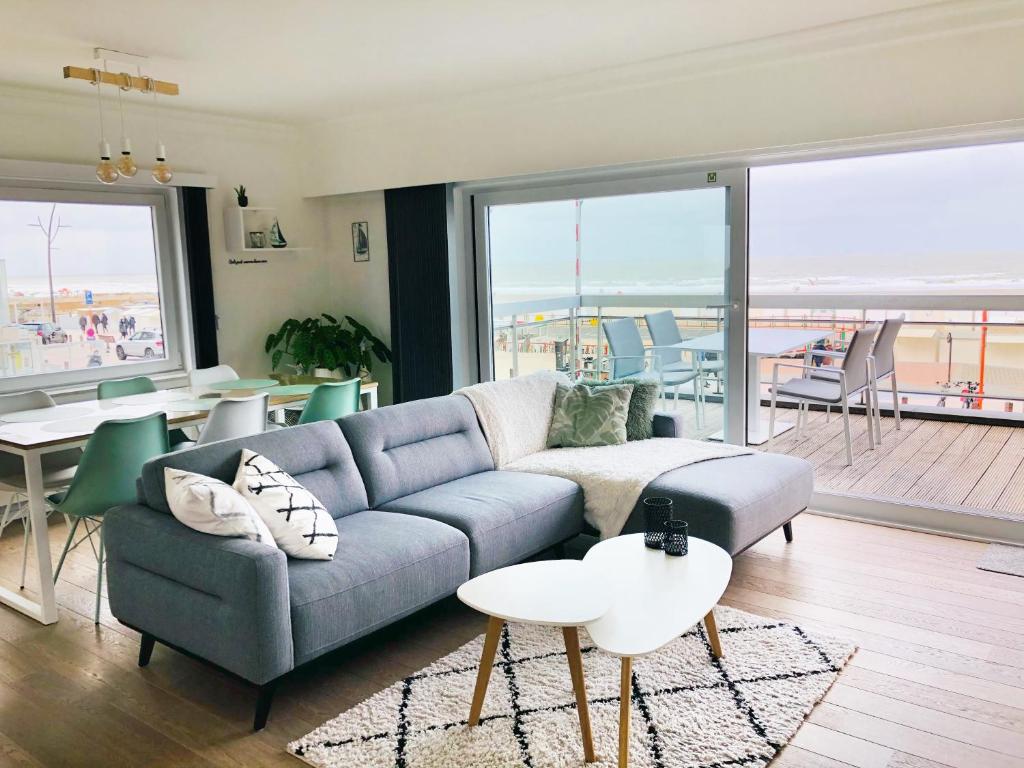 a living room with a couch and a table at Luxueus appartement met ruim terras, frontaal zeezicht 4 à 5 personen in Blankenberge