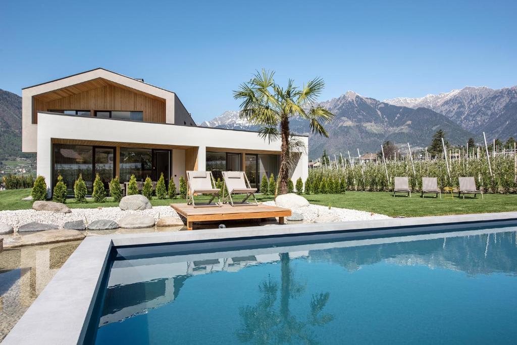 una casa con piscina frente a una casa en Das Heacher, en Merano